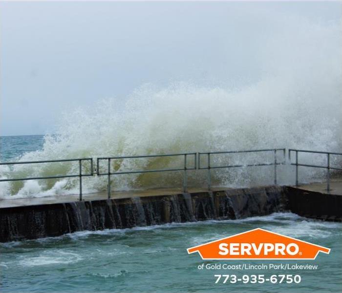 Lake Michigan waves crash over a railing.